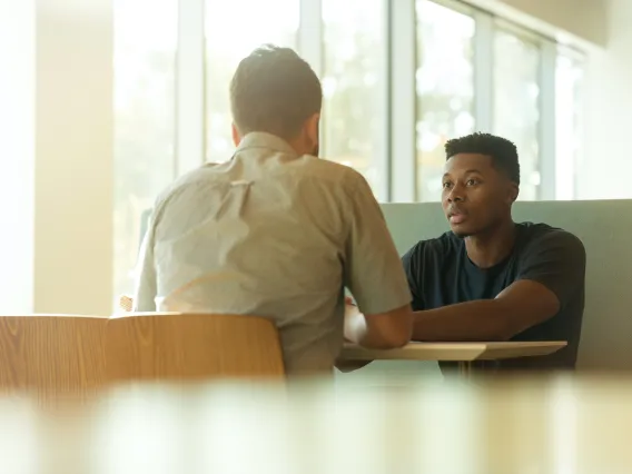 two people sitting at a table talking