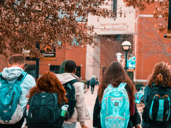 group of people wearing backpacks seen from behind