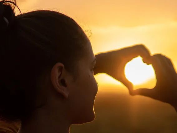 person making a heart with their hands