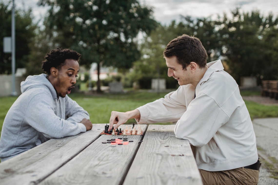 two people playing chess outdoors