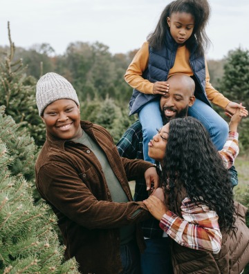 a family looking at Christmas trees laughing